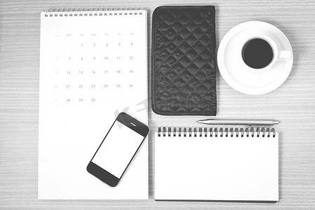 桌面：带电话的咖啡、记事本、钱包、日历黑色和白色
