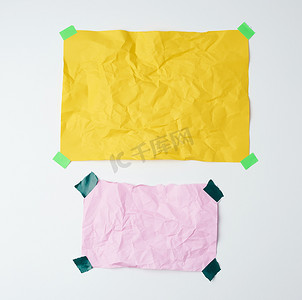 空的黄色和粉色皱巴巴的纸片，上面粘着绿色