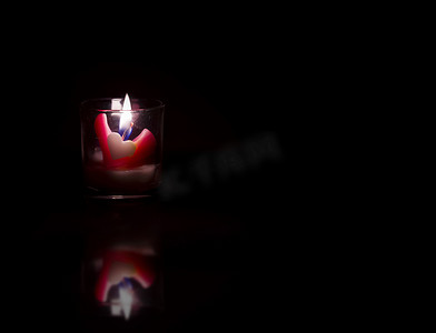 平静的心摄影照片_黑色背景中的心形蜡烛