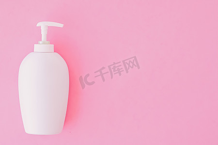 粉红色背景的一瓶抗菌液体皂和洗手液、卫生用品和保健品