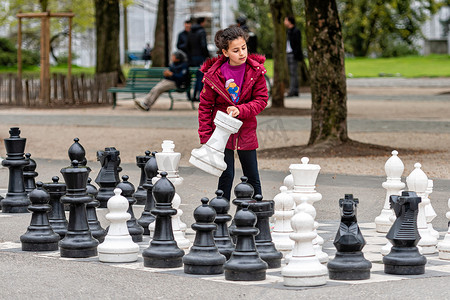 人们在 Parc des Bastions 玩传统的超大型街头象棋