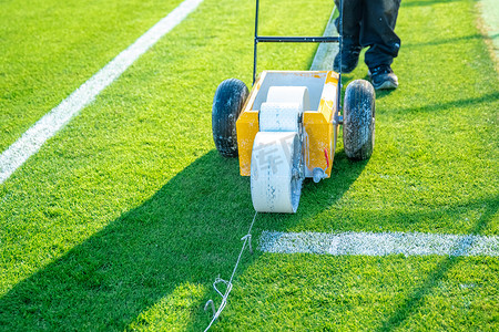 赛前用特殊机器在草地上用白色油漆在足球场上画白线