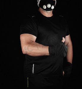 身穿黑色制服、训练面具和双手包裹在 bla 中的运动员