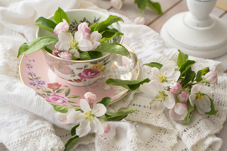 花朵花边背景摄影照片_破旧别致和粉红色复古杯子上的手工花边，上面有白色的花朵。
