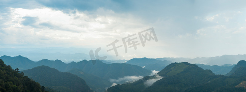 高山树摄影照片_被雾覆盖的全景高山。