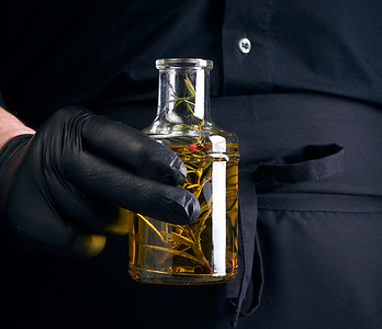 乳汁摄影照片_黑衣服的人，乳汁手套拿着一个透明瓶wi