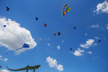 猴子玩具摄影照片_个风筝在蓝蓝的天空中飞翔。