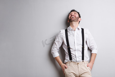 穿着吊带裤的快乐男人笑着抬头