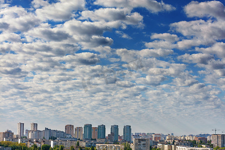 太阳光线摄影照片_灰色的小云逐渐遮蔽了城市上空的蓝天。