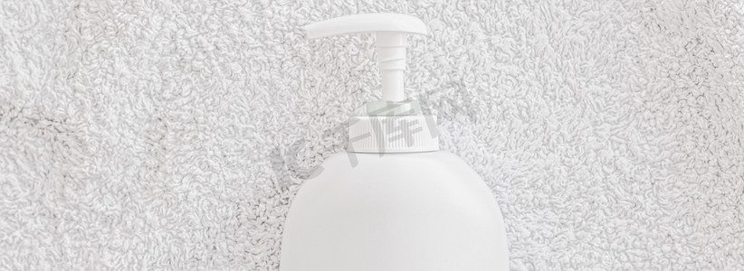 空白标签化妆品容器瓶作为白毛巾背景上的产品模型