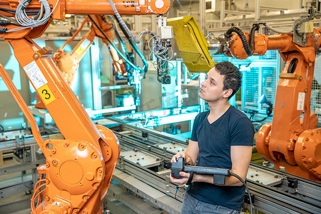 工程师使用工厂工业机器人的远程控制进行控制。