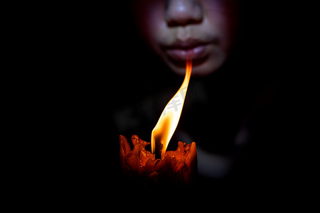 生日风摄影照片_面孔女人吹灭黑色背景中的蜡烛
