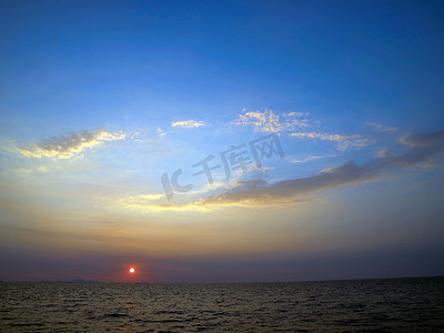 黑色椭圆摄影照片_海上日落和椭圆云蓝天