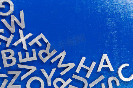 蓝色背景上银色金属字母字符的抽象平面背景，具有一半的框架填充和复制空间