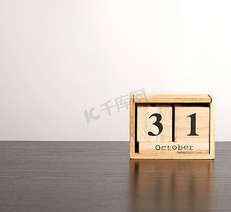 黑色标签摄影照片_黑色标签上日期为 10 月 31 日的立方体木制日历