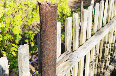 春夏花园旧生锈金属管、柱子和木栅栏
