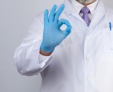 穿着带纽扣的白大衣的医生展示了一个手势，他的手势很好