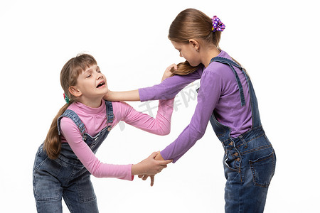 两个女孩争吵摄影照片_两个女孩打架并互相伤害