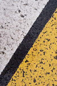 具有破裂的白色和黄色条纹的沥青公路纹理