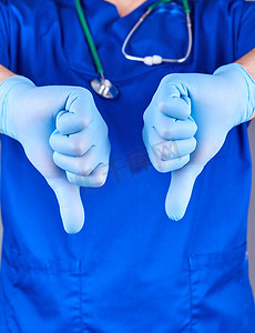 穿着蓝色制服和乳胶无菌手套的医生展示了一个手势