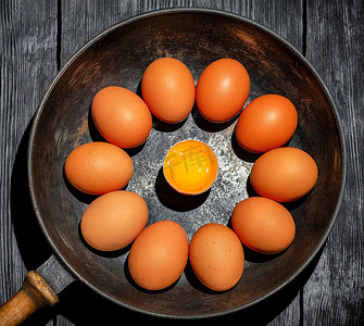 旧铸铁煎锅中的棕色鸡蛋在中央看起来是一个破碎的鸡蛋，蛋黄明亮。