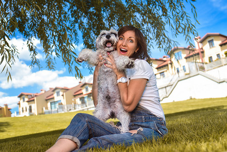 白人快乐的女人在公园里和她心爱的狗玩耍。
