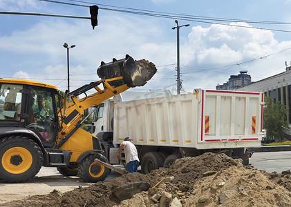 装入摄影照片_机动施工拖拉机将建筑垃圾装入卡车