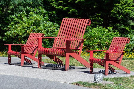 Van 公园阳光下的三把公共红色木椅