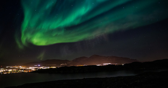 绿色大气摄影照片_巨大的绿色北极光照耀着格陵兰岛努克市