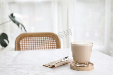 拿牛奶摄影照片_木桌上用牛奶制成的卡布奇诺或拿铁艺术咖啡