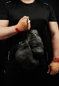 一件黑色制服的肌肉运动员拿着非常老黑拳击