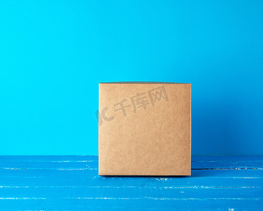 蓝色背景中闭合的方形棕色礼盒