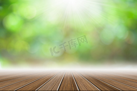 木地板场景背景与太阳光束的绿色散景模糊