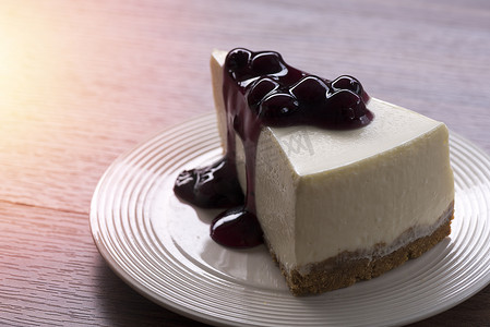 木桌白盘蓝莓奶油芝士蛋糕