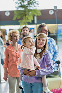 度假的家人在机场排队办理登机手续