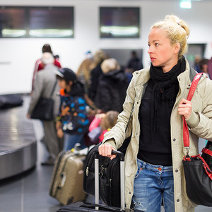 女性旅客在机场运送行李。