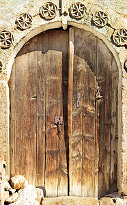 古色古香的拱形木门，中间有石纹和金属锁。