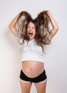 孕妇生病摄影照片_年轻美丽的孕妇在白色背景下经历强烈的情绪