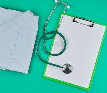 绿色背景上空的白床单和医用听诊器