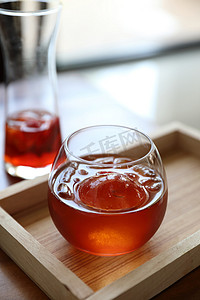 红色茶摄影照片_木桌上的草莓冰茶