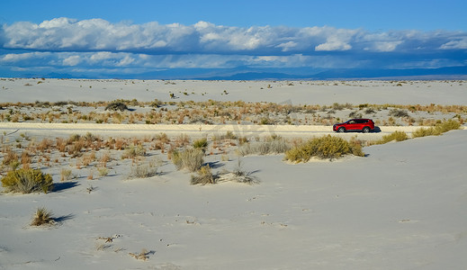 新墨西哥州摄影照片_红色汽车乘着沙丘的危害从石膏到美国新墨西哥州白沙国家纪念碑