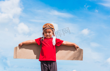 飞机机翼摄影照片_小男孩微笑着戴飞行员帽玩玩具飞机机翼