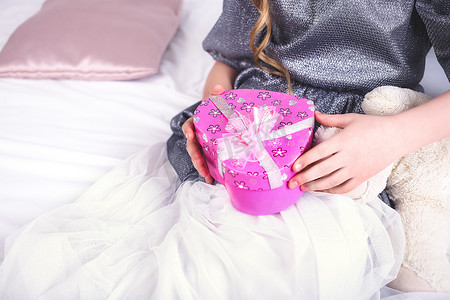 生日快乐背景粉色摄影照片_拿着红色礼物盒的年轻微笑的妇女