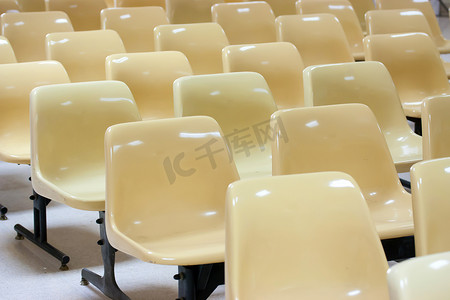 许多排空的黄色塑料椅子