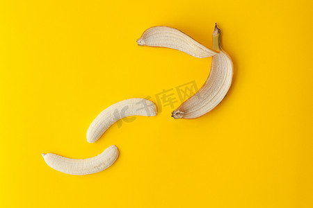 剥香蕉摄影照片_在黄色背景上剥香蕉和水果