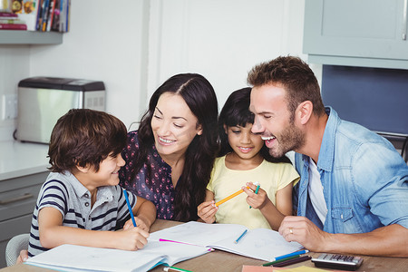 快乐的父母在家庭作业中协助孩子