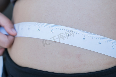 超重肥胖的亚洲年轻女性用卷尺测量她的腹部 p