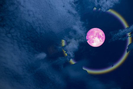满粉红色的光晕月亮和夜空中的彩虹