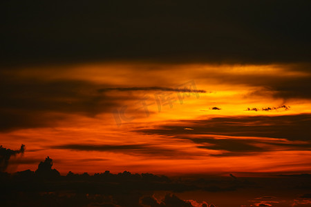 淡红色摄影照片_海洋上的夕阳最后一抹淡红色和橙色的天空剪影云