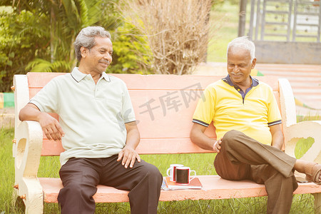 活跃的退休老人和休闲理念 — 两个年长的朋友晚上在户外喝咖啡聊天 — 两个年长的兄弟玩得很开心。